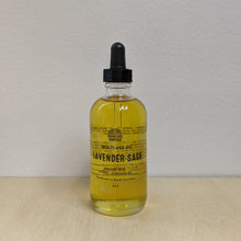 Load image into Gallery viewer, Glass bottle with black dropper lid containing golden multi use oil by Motherland Essentials reads &quot;lavender sage&quot; in black block letters available at Coyote Supply Co, a zero waste witch store in Midtown Reno, Nevada that is BIPOC owned
