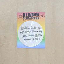 Load image into Gallery viewer, Suncatcher sticker by Hills + Holler. Round sticker appears pearlescent white and reads &quot;a spell cast on this whole place for love, light, &amp; the freedom to be!&quot; in handwritten block letters. Sticker is on a rainbow background.  available at Coyote Supply Co, a zero waste witch store in Midtown Reno, Nevada that is BIPOC owned