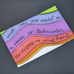 Interior of greeting card by Amador Collective features a wavy rainbow background and reads "and now my world is a vision of technicolor you inspired my vivid heart" in black handwritten letters available at Coyote Supply Co, a zero waste witch store in Midtown Reno, Nevada that is BIPOC owned