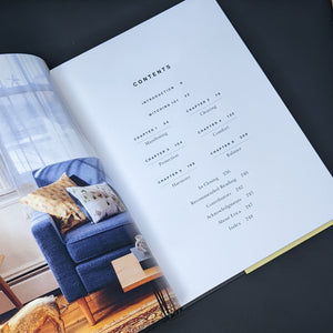 Table of contents featuring black text on white pages; photo of a colorful living room on the facing page.