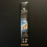 A glossy black cardboard envelope with brown embellishments. The envelope has an illustration of a wolf howling at a crescent moon. 
The envelope reads, 
