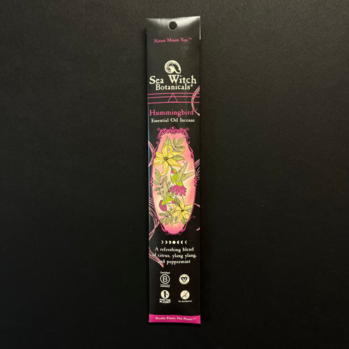 A glossy black cardboard envelope of incense with pink embellishments. The center has an illustration of humming birds drinking nectar from yellow flowers. The box reads