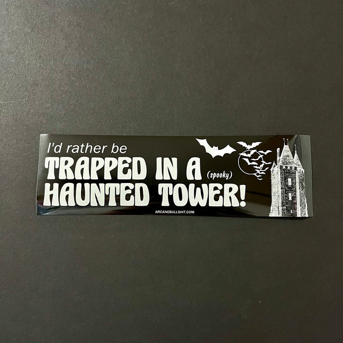 A black bumper sticker with bats, a tower, and white text that reads: I'd rather be trapped in a (spooky) haunted tower!  Sold at Coyote Supply Co a BIPOC and LGBTQIA+ owned zero waste witch store in Reno Nevada 