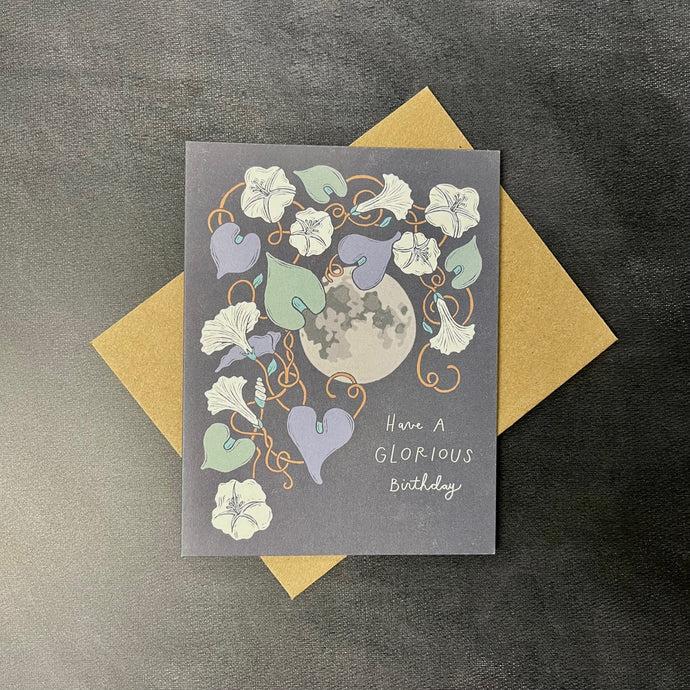 A navy blue birthday card with illustrartions of a full moon and moonflowers. The card reads 