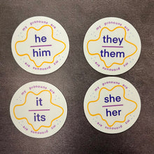 Load image into Gallery viewer, Four round stickers with pronoun labels on a dark background. The stickers list he/him, they/them, it/its, and she/her.

This item is sold at Coyote Supply Co a BIPOC and LGBTQIA+ owned zero waste witch store in Reno Nevada