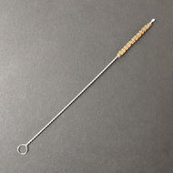 A boba straw brush comprised of a twisted metal and natural brown bristles on a black background.  Sold at Coyote Supply Co a BIPOC and LGBTQIA+ owned zero waste witch store in Reno Nevada 