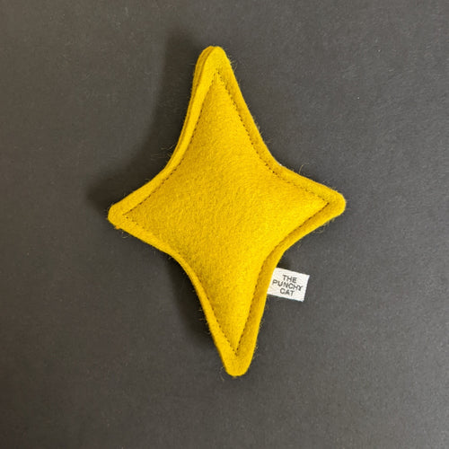 A yellow felt four pointed star on a black background.
Sold at Coyote Supply Co a BIPOC and LGBTQIA+ owned zero waste witch store in Reno Nevada