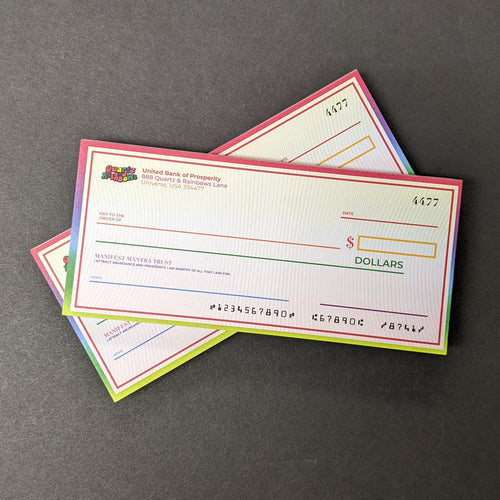 A stack of two sets of Manifestation check pads. The checks have a light rainbow gradient background and saturated rainbow border. The top left corner of the check has a Quartz and Rainbows logo and text that reads 