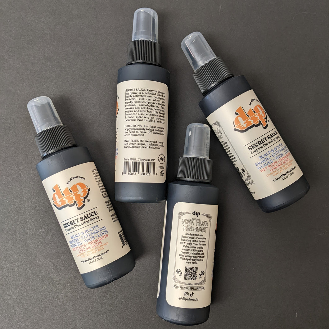 Four black spray top bottles arranged in a zig zag with beige labels that read Dip Secret Sauce Enzyme Cleaning Spray. Sold at Coyote Supply Co a BIPOC and LGBTQIA+ owned zero waste witch store in Reno Nevada