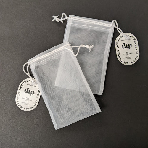 Two white mesh drawstring Dip bar saver bags on a black background. Sold at Coyote Supply Co a BIPOC and LGBTQIA+ owned zero waste witch store in Reno Nevada