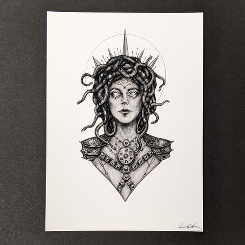 Black drawing on white paper of the Medusa from the chest up. Her hair snakes, she's wearing a spiked crown, she's backlit with a halo, and she's wearing a draped chain headpiece that lays across her forehead. She sports armour and a jeweled chest piece. Available at Coyote Supply Co, a zero waste witch store in Midtown Reno, Nevada that is BIPOC owned