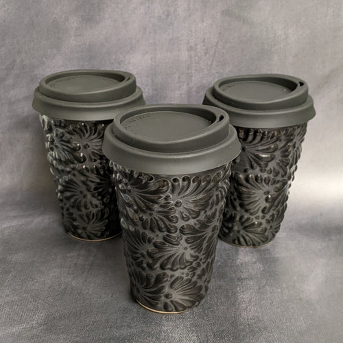 Three black travel mugs with a black floral Talavera pattern against a grey background, each with a silicone lid.
Sold at Coyote Supply Co a BIPOC and LGBTQIA+ owned zero waste witch store in Reno Nevada