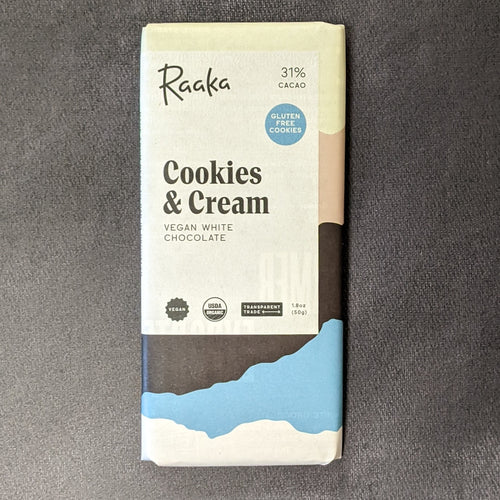 A paper wrapped chocolate bar, the paper has a white square with black text and colors from top to bottom of white, grey, black, blue, and white. The label has black text that reads 