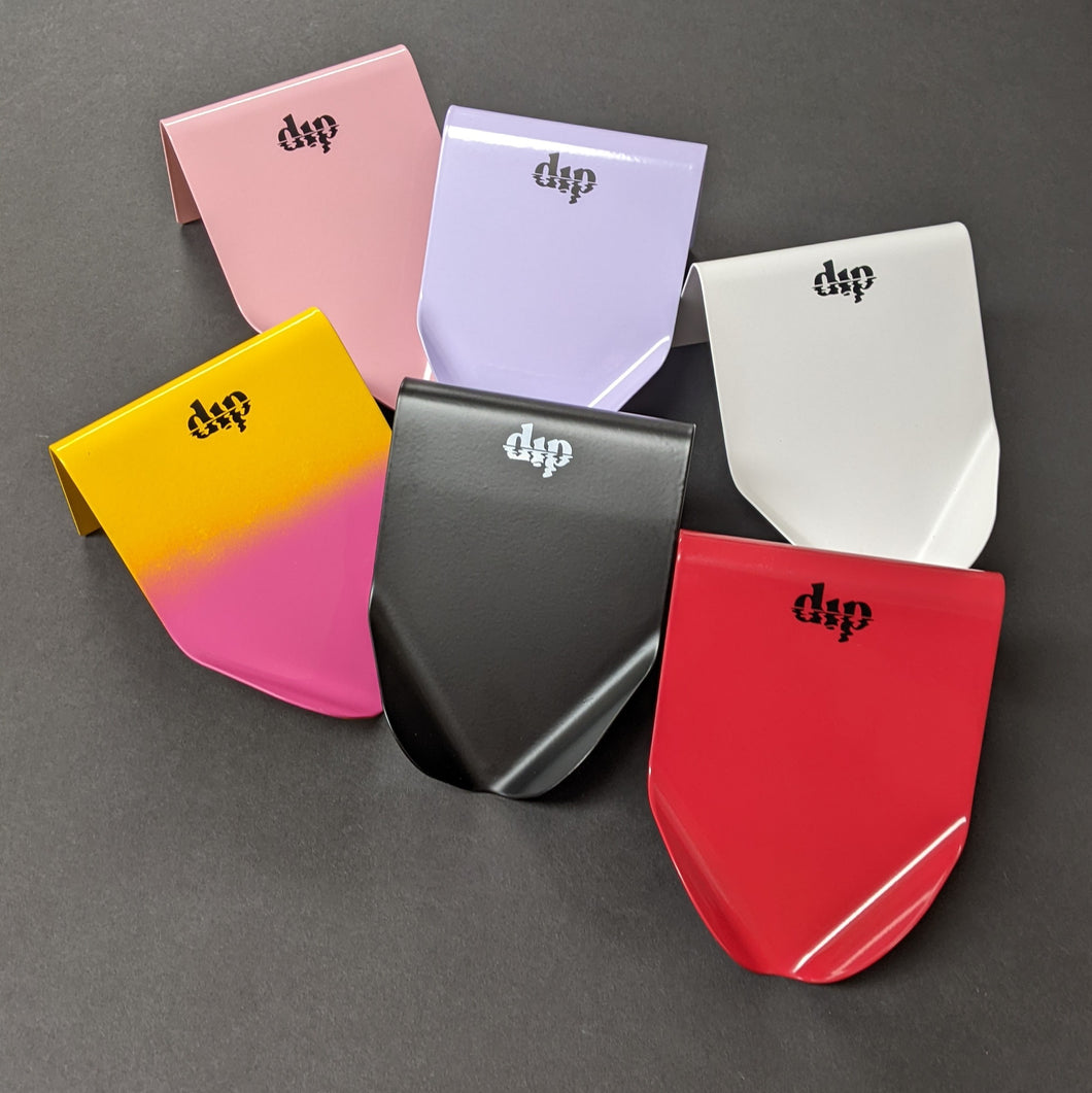 Six metal soap saver dishes with Dip branding. From top left to bottom right the colors are pink, lavender, white, yellow-pink ombre, black, and red. Sold at Coyote Supply Co a BIPOC and LGBTQIA+ owned zero waste witch store in Reno Nevada