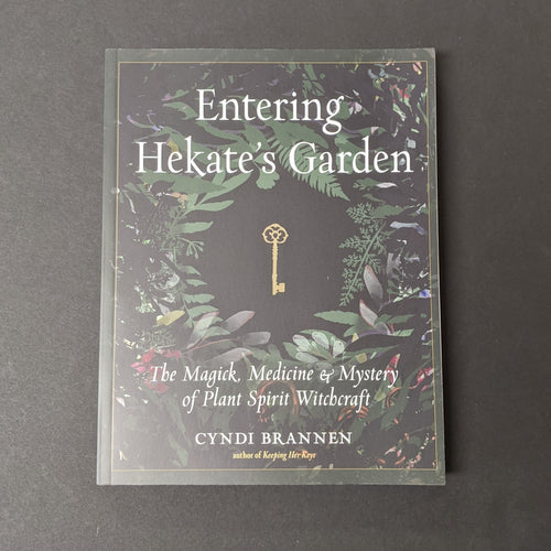 A black book cover with images of foliage and an antique key in the center by Cyndi Brannen. Sold at Coyote Supply Co a BIPOC and LGBTQIA+ owned zero waste witch store in Reno Nevada 