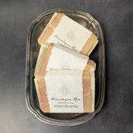 Three tan soap bars with white bands in a silver plate on a black background. The white bands have black text that reads:
Himalayan Rose
Handmade Salt Bar
Palm-Oil Free * Organic Ingredients
No Chemical Preservatives * Vegan

This item is sold at Coyote Supply Co a BIPOC and LGBTQIA+ owned zero waste witch store in Reno Nevada