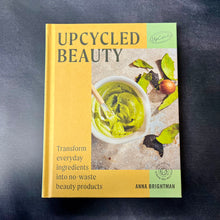 Load image into Gallery viewer, Hard cover yellow book on a dark background. The cover reads:
Upcycled Beauty
Transform everyday ingredients into no-waste beauty products
Anna Brightman.

This item is sold at Coyote Supply Co a BIPOC and LGBTQIA+ owned zero waste witch store in Reno Nevada