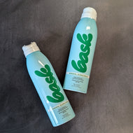 Blue Bask sunscreen bottle with a white spray cap on a dark grey background.

The bottle reads:
Bask
mineral sunscreen
non-aerosol
continuous spray 
broad spectrum 
SPF 30 

Sold at Coyote Supply Co a BIPOC and LGBTQIA+ owned zero waste witch store in Reno Nevada 