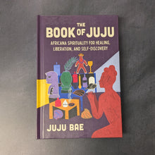 Load image into Gallery viewer, A purple hardcover book on a dark background. The cover reads:
The
Book of Juju
Africana Spirituality For Healing
Liberation, and Self-Discovery
Juju Bae

This item is sold at Coyote Supply Co a BIPOC and LGBTQIA+ owned zero waste witch store in Reno Nevada
