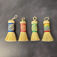 Four escobetas of assorted twine colors on a black background. From left to right the colors are, blue, red, green, and rainbow.
Sold at Coyote Supply Co a BIPOC and LGBTQIA+ owned zero waste witch store in Reno Nevada