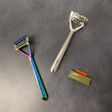 Load image into Gallery viewer, Two plastic free Leaf Shave pivoting head triple blade razors and a pack of single edge blades. One razor is an iridescent chrome and the other is a silver polished metal. Sold at Coyote Supply Co a BIPOC and LGBTQIA+ owned zero waste witch store in Reno Nevada