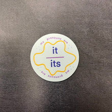 Load image into Gallery viewer, A round pronoun label sticker for it/its on a dark background. 
This item is sold at Coyote Supply Co a BIPOC and LGBTQIA+ owned zero waste witch store in Reno Nevada