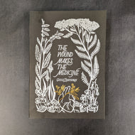 A black paperback book cover with white illustrations of plants and one gold plant on a heart, the cover has white thin text that reads 