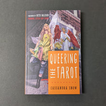 Load image into Gallery viewer, An illustrated book cover depicting a woman holding a spray paint cand next to a mural of the tarot card Temperance by Cassandra Snow. Reads Queering the Tarot in thin white letters. Available at Coyote Supply Co, a zero waste witch store in Midtown Reno, Nevada that is BIPOC owned
