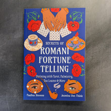 Load image into Gallery viewer, Blue book cover that reads 'Secrets of Romani Fortune Telling' by Paulina Stevens and Jezmina Von Thiele with colorful illustrations on a black background.
Sold at Coyote Supply Co a BIPOC and LGBTQIA+ owned zero waste witch store in Reno Nevada