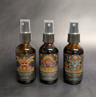 Three amber glass spritz bottles with colorful labels on a dark background. 
From left to right the labels read, Agua De Tlaloc, Agua De Tonatiuh, Agua De Xochipilli. 

This item is sold at Coyote Supply Co a BIPOC and LGBTQIA+ owned zero waste witch store in Reno Nevada