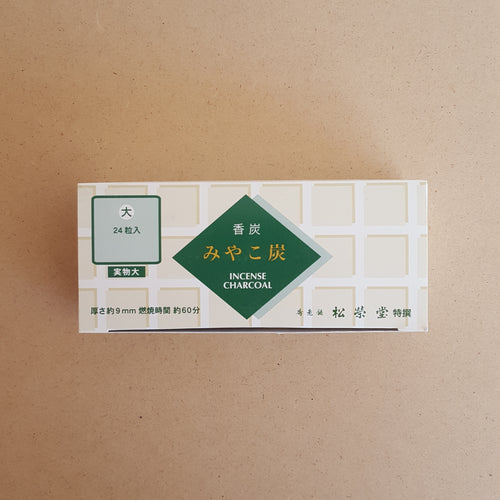 Top of charcoal box features green geometric shapes on a white and tan background with Japanese writing by Shoyeido available at Coyote Supply Co, a zero waste witch store in Midtown Reno, Nevada that is BIPOC owned