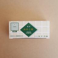 Top of charcoal box features green geometric shapes on a white and tan background with Japanese writing by Shoyeido available at Coyote Supply Co, a zero waste witch store in Midtown Reno, Nevada that is BIPOC owned