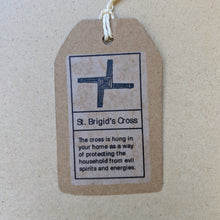 Load image into Gallery viewer, Detail of kraft paper hang tag that accompanies each cross.  Top has black drawing of the cross, bottom text reads &quot;The cross is hung in your home as a way of protecting the household from evil spirits and energies.&quot; in black ink.