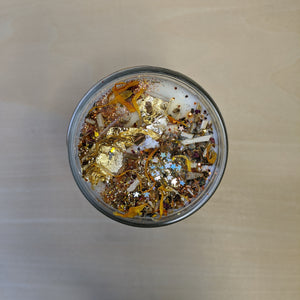 White soy wax candle topped with confetti, herbs including marigolds, and gold leaf by Firme Arte available at Coyote Supply Co, a zero waste witch store in Midtown Reno, Nevada that is BIPOC owned