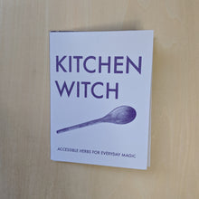 Load image into Gallery viewer, Purple text on lavender paper reads &quot;Kitchen Witch Accessible Herbs for Everyday Magic&quot; and features a photo of a wooden spoon  by Snake Hair Press available at Coyote Supply Co, a zero waste witch store in Midtown Reno, Nevada that is BIPOC owned