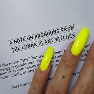 Black text on white paper reads "A note on pronouns from the lunar plant witches".  Boss Witch's hand is on the page too & their nails are fluorescent green. 