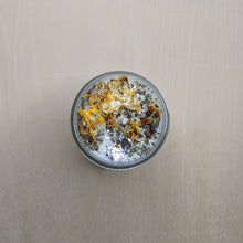 Load image into Gallery viewer, White soy wax candle topped with marigold petals, herbs, and gold leaf by Firme Arte available at Coyote Supply Co, a zero waste witch store in Midtown Reno, Nevada that is BIPOC owned