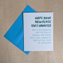 Load image into Gallery viewer, Teal envelope layered under a white card that reads &quot;hope your new place isn&#39;t haunted but if it is haunted that the ghost is helpful and maybe folds your laundry or takes out the trash or something&quot; in green &amp; mint available at Coyote Supply Co, a zero waste witch store in Midtown Reno, Nevada that is BIPOC owned