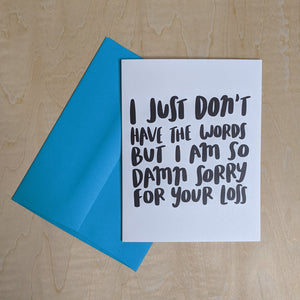 Teal envelope layered under a white paper card with black text that reads "I just don't have the words but I am so damn sorry for your loss." available at Coyote Supply Co, a zero waste witch store in Midtown Reno, Nevada that is BIPOC owned