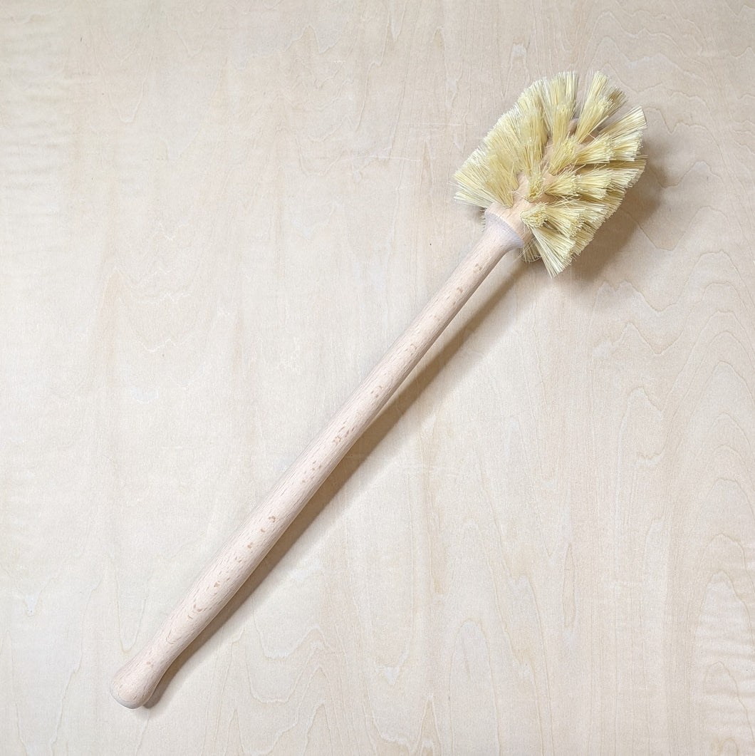Wooden handled toilet brush with sisal bristles pointed towards the top right corner available at Coyote Supply Co, a zero waste witch store in Midtown Reno, Nevada that is BIPOC owned