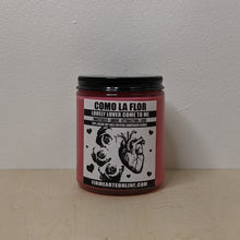 Load image into Gallery viewer, Red soy wax spell candle in a clear glass jar with a black lid.  Black &amp; white label reads &quot;Como La Flor, lovely lover come to me, sweetness, amor, attraction, love&quot; &amp; features art of 3 roses &amp; an anatomically correct heart.  Made by Firme Arte &amp; sold by zero waste witch store Coyote Supply Co in Reno, Nevada.