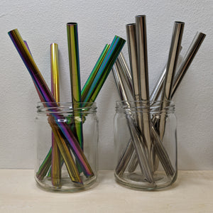 Two glass jars of stainless steel boba straws. Jar on the left contains rainbow anodized straws. Jar on the right contains silver straws by Shuki available at Coyote Supply Co, a zero waste witch store in Midtown Reno, Nevada that is BIPOC owned