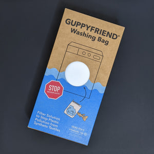 Brown and blue cardboard box containing a GuppyFriend washing bag available at Coyote Supply Co, a zero waste witch store in Midtown Reno, Nevada that is BIPOC owned
