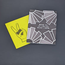 Load image into Gallery viewer, Greeting card and envelope by Amador Collective. Lime Green envelope features an image of a hand giving the peace sign and holding a heart. Card features a black background with white outlined geometric shapes in the corners and reads &quot;before you, my life was black + white&quot; in white hand written letters available at Coyote Supply Co, a zero waste witch store in Midtown Reno, Nevada that is BIPOC owned