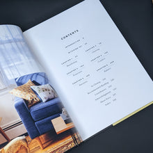 Load image into Gallery viewer, Table of contents featuring black text on white pages; photo of a colorful living room on the facing page.