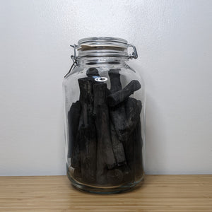 Large glass jar with metal hinge containing black charcoal water filters by Mizzl  available at Coyote Supply Co, a zero waste witch store in Midtown Reno, Nevada that is BIPOC owned