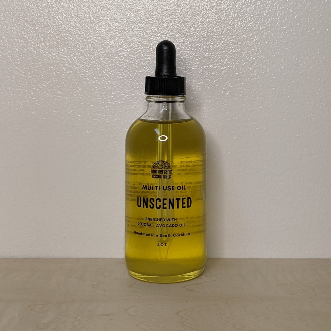 Glass bottle with black dropper lid containing golden multi use oil by Motherland Essentials reads 