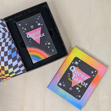 Load image into Gallery viewer, Open box holds the queer tarot deck by Ash + Chess, featuring a pink triangle and a rainbow in POC inclusive pride flag colors. The lid of the box features a wavy rainbow checkerboard. Next to it is the rainbow cover guidebook.