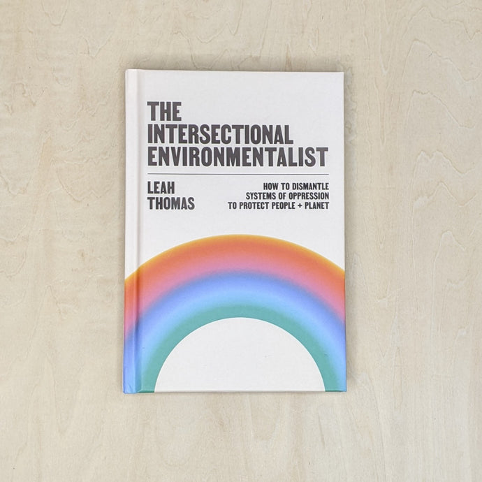 The Intersectional Environmentalist by Leah Thomas. Off white cover features  gradient arching across the lower half. Gradient transitions through the rainbow from red to green  available at Coyote Supply Co, a zero waste witch store in Midtown Reno, Nevada that is BIPOC owned