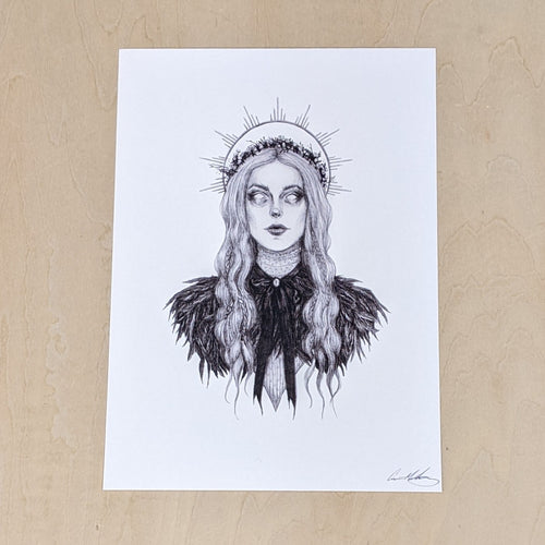 Black drawing on white paper of the Norse Goddess Freyja from the chest up. Her hair is long & wavy & topped with a thin flower crown & she has a halo shining behind her head. She sports a long necked Victoian style top covered by a fur cape tied by a long bow. Available at Coyote Supply Co, a zero waste witch store in Midtown Reno, Nevada that is BIPOC owned